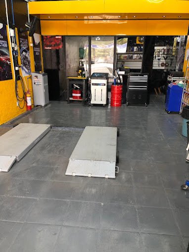 Área de serviço da oficina com rampas e máquina de troca de fluido de câmbio