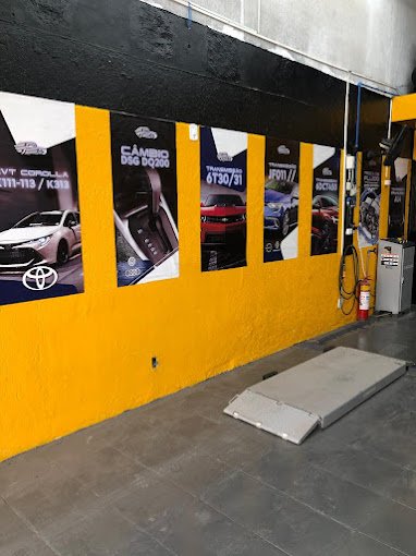 Parede amarela da oficina com pôsteres de câmbios automáticos